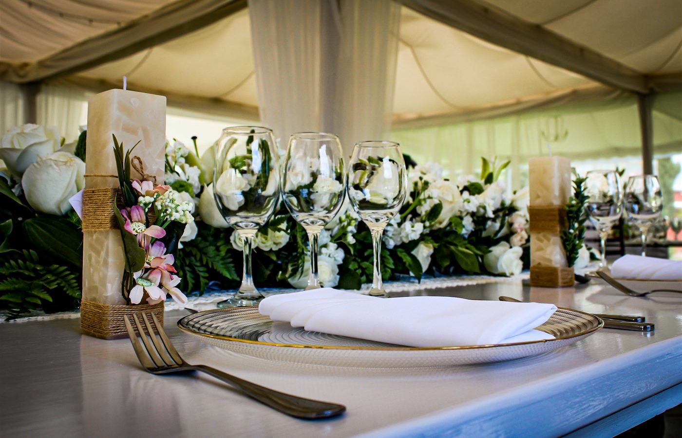 Mesa de evento formal con flores, copas y velas